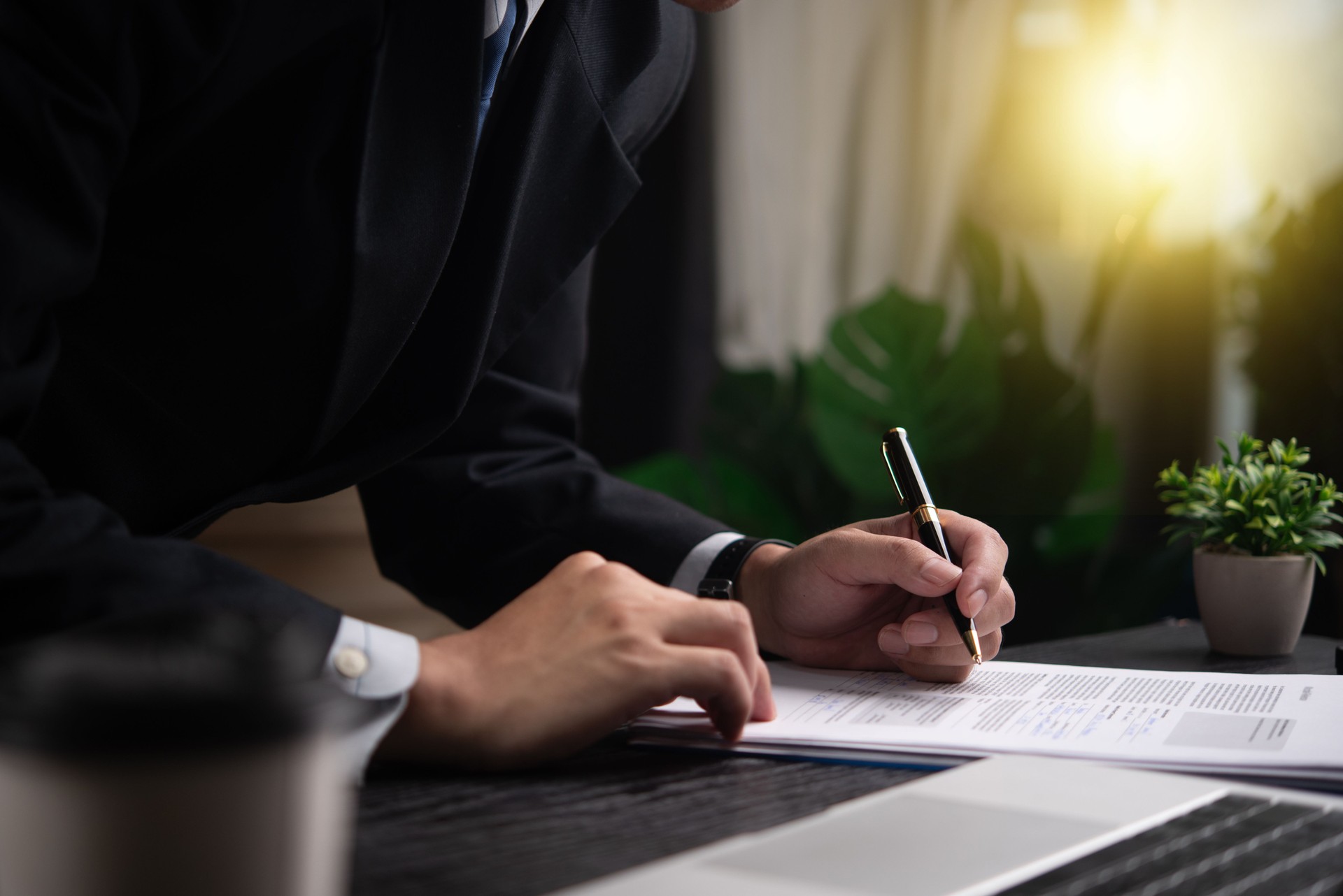 Businessman signing a document at desk, closeup on hand and pen. Represents professionalism, formal agreement, contract completion. Perfect for legal, corporate contexts.