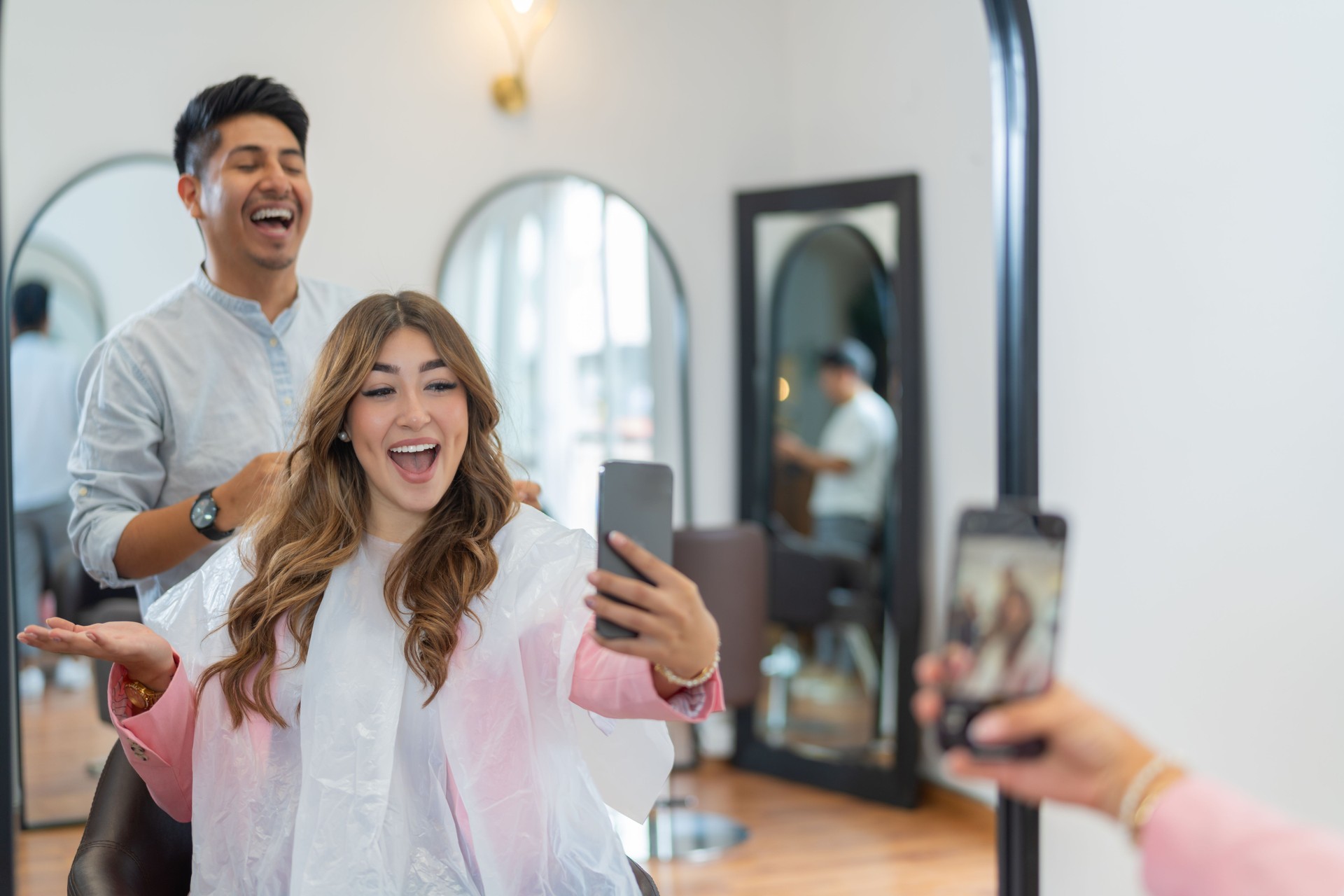 Influencer taking a selfie with a professional hairdresser in a salon